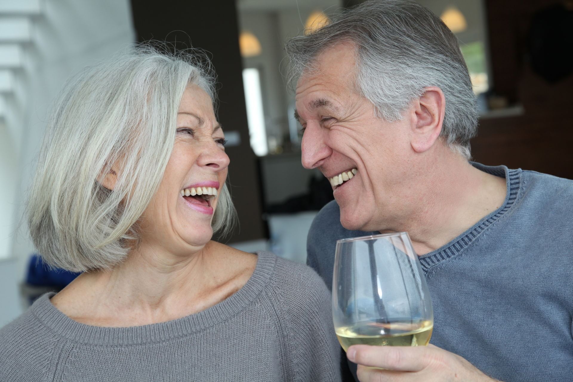 Couple laughing and drinking white wine