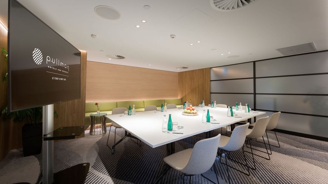 Interior of the Elara Boardroom with refreshments and a TV at Pullman Sydney Olympic Park