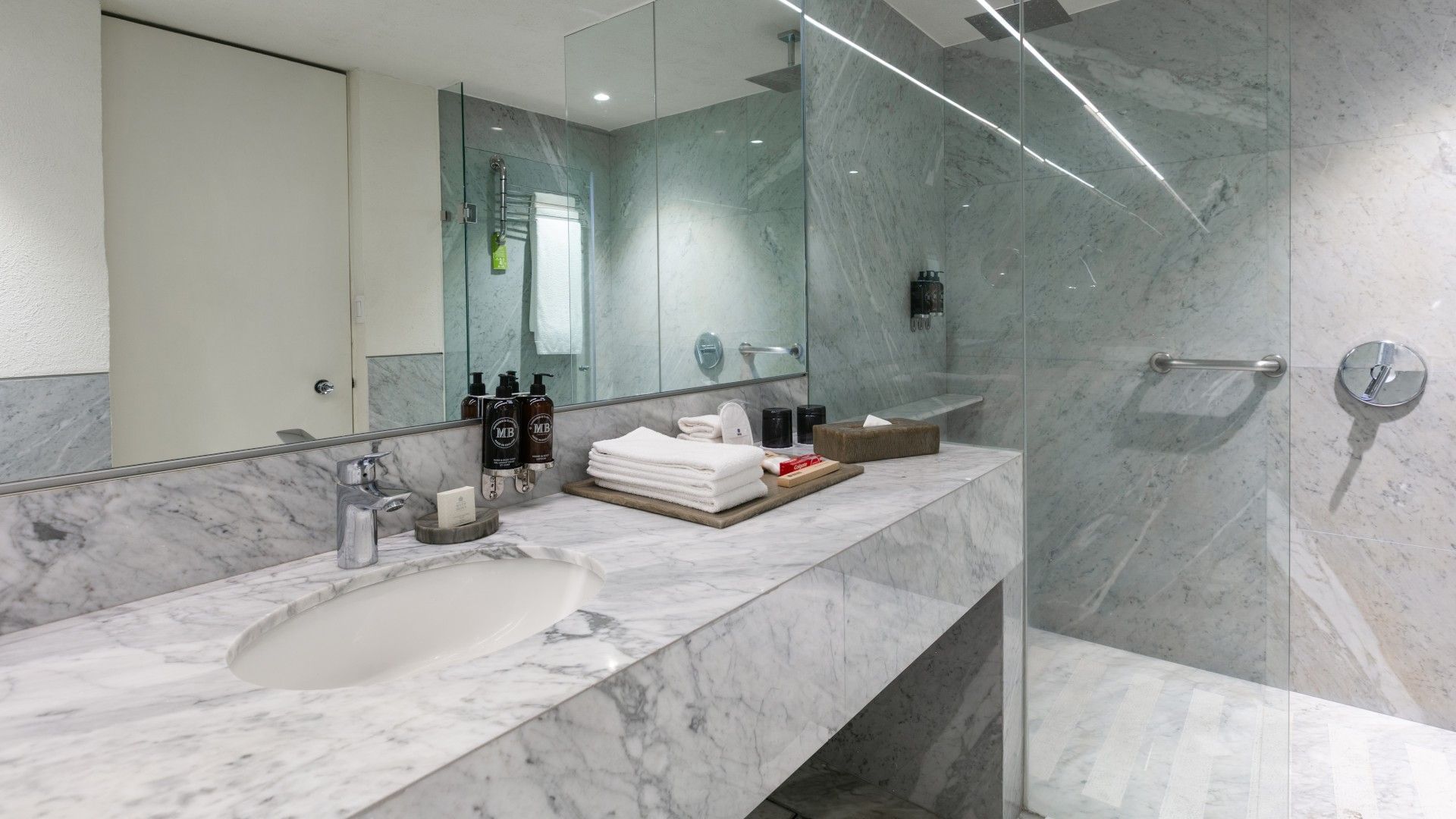 2 Double Junior Suite marble bathroom featuring a glass walk-in shower and premium towels at Camino Real Polanco Mexico