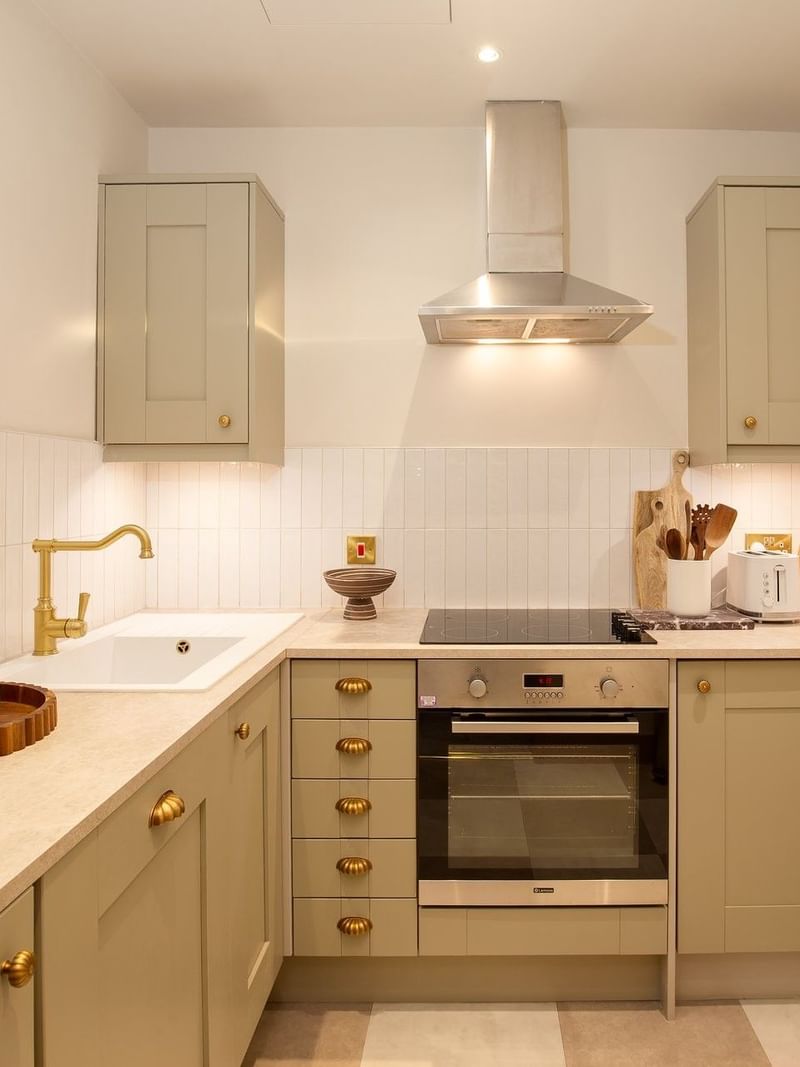 Studio Apartment kitchenette with cabinetry & appliances by a marble counter at The Capital Hotel, Apartments and Townhouse
