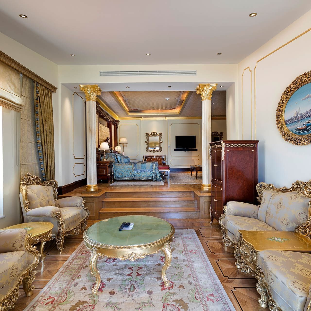 Titanic Mardan Palace'ın King Süitinde rahat şezlonglar ve masa içeren zarif bir yaşam alanı