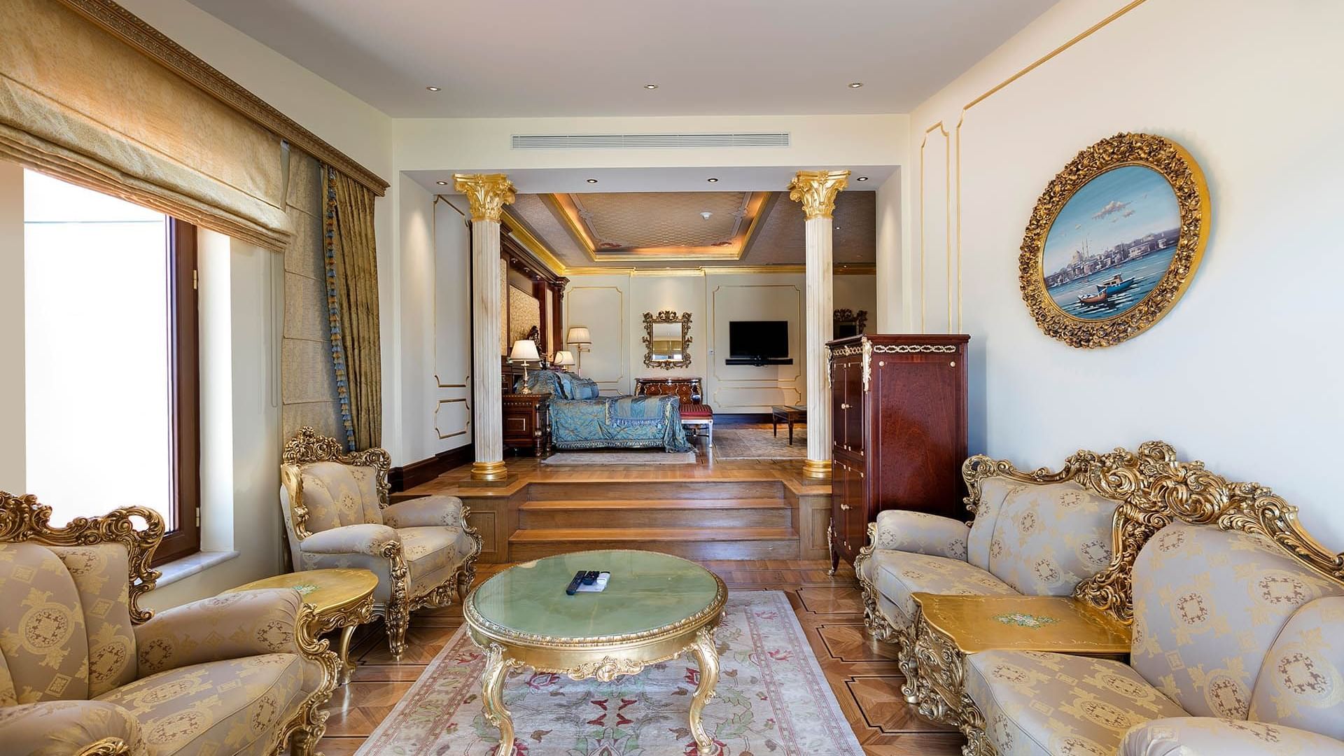Titanic Mardan Palace'ın King Süitinde rahat şezlonglar ve masa içeren zarif bir yaşam alanı