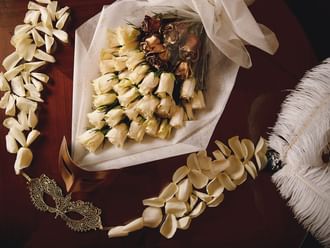 Close-up of flower bouquet & masquerade masks at Palazzo Versace