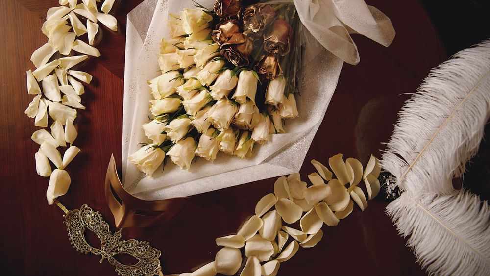 Close-up of flower bouquet & masquerade masks at Palazzo Versace
