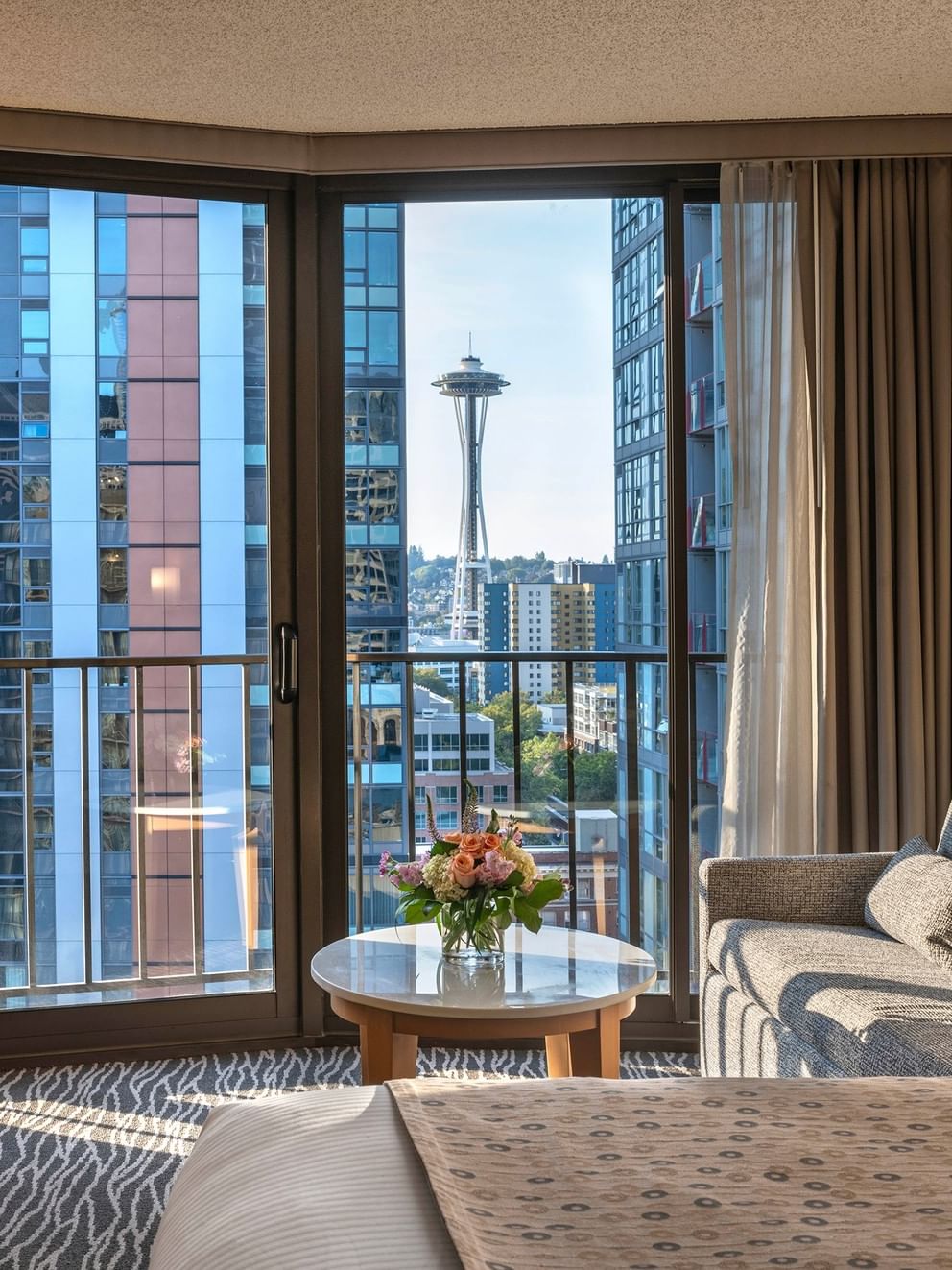 Premier Room features Grey sofa by a marble coffee table under a city view window at Warwick Seattle