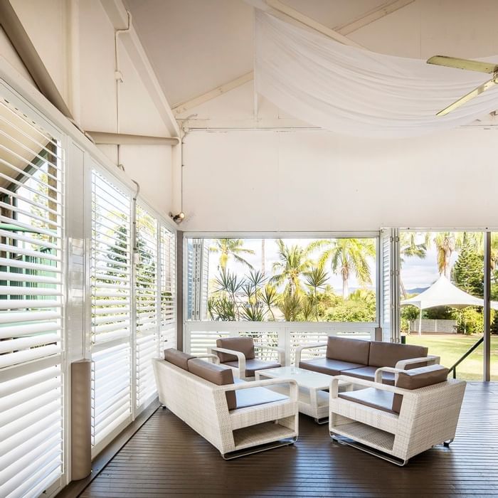 Plantation Deck with wicker furniture and windows with greenery view at Mercure Hotel Townsville