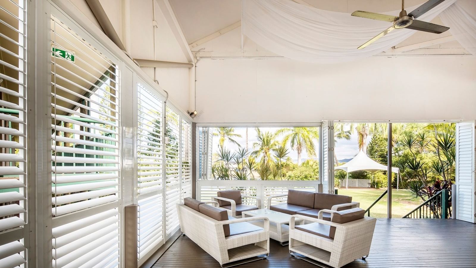 Plantation Deck with wicker furniture and windows with greenery view at Mercure Hotel Townsville