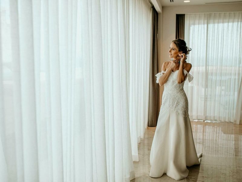 A bride wearing an earing looking outside at Live Aqua Resorts
