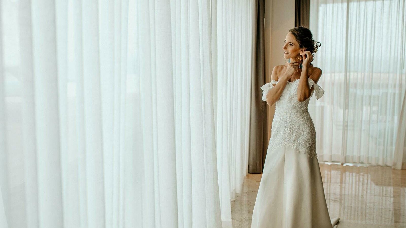 A bride wearing an earing looking outside at Live Aqua Resorts