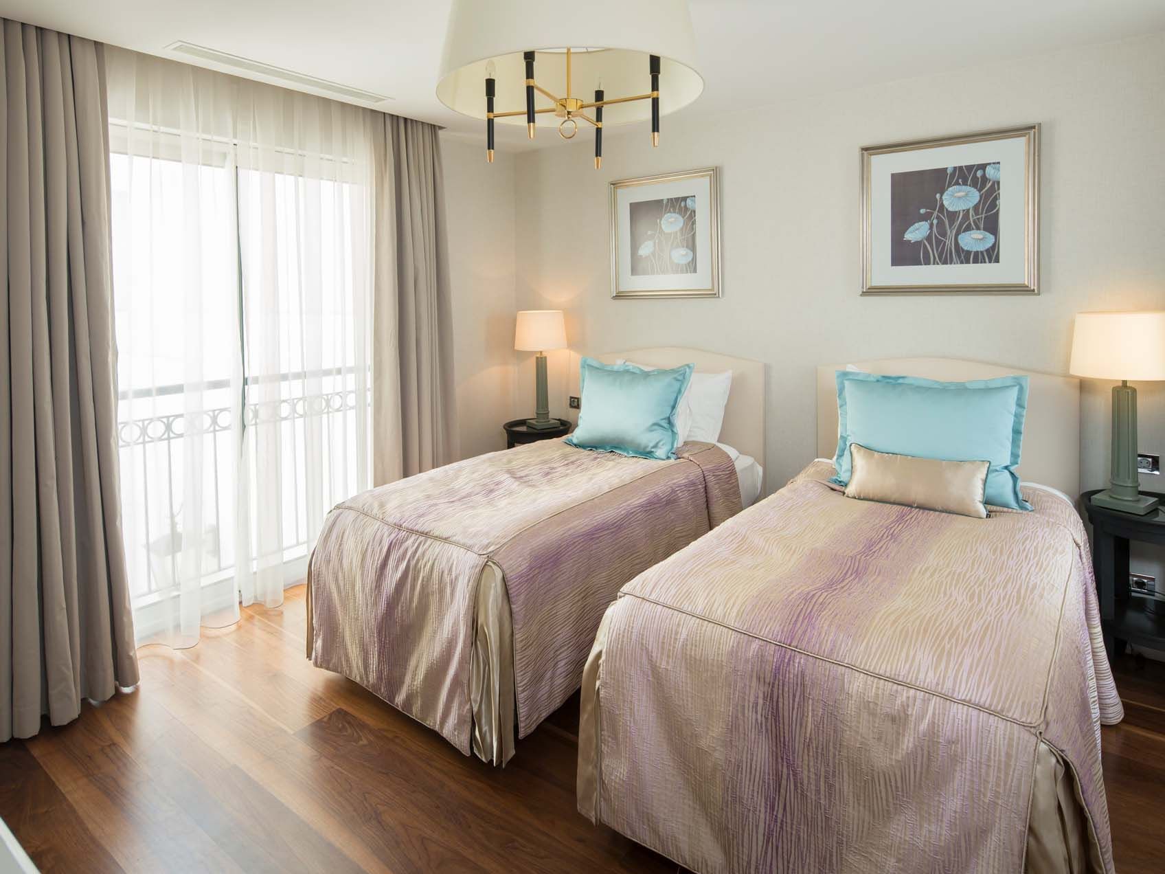 Two twin beds with side tables in a room at Titanic Deluxe Golf Belek