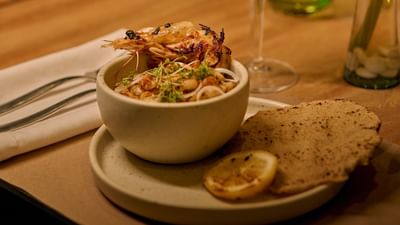 An elegant upscale appetizer served with crispy garnishes inside a beachfront boutique hotel restaurant.