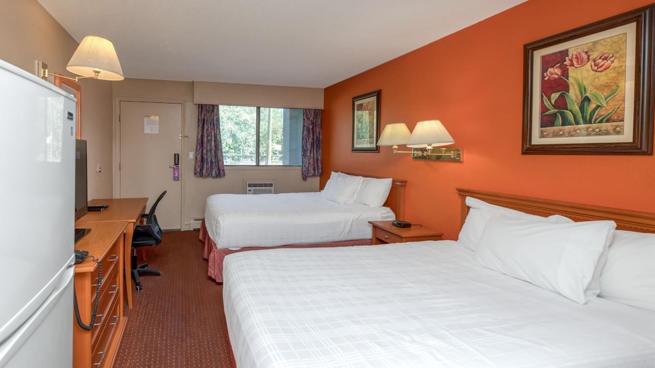 Guest room at Coast Red Deer Hotel with two queen beds, desk and TV