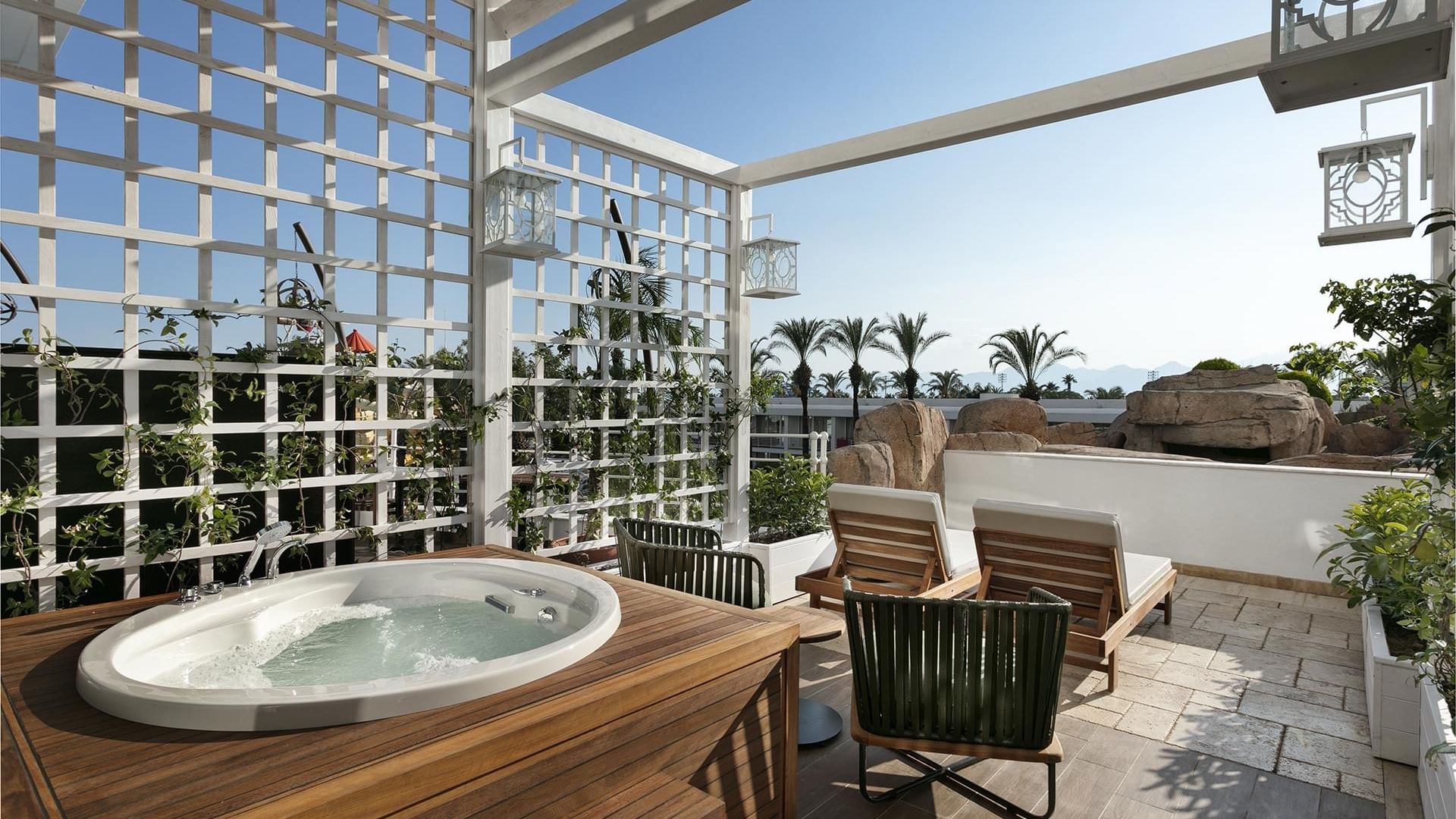 Терраса в Titanic Deluxe Lara – Annex Duplex Suite с джакузи и элегантной зоной отдыха с деревянным покрытием.