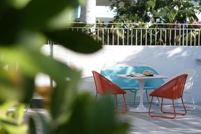 Outdoor seating area with different color chairs and a hat and b