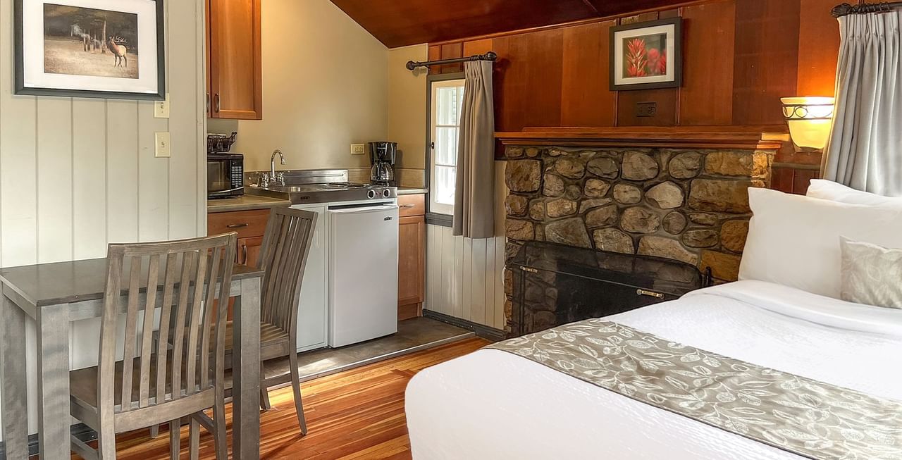Interior of cabin with dining area, bed, and kitchen
