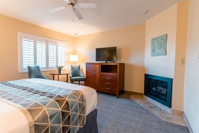 A beautifully appointed hotel room featuring a cozy fireplace and modern furniture at Carmel Bay View Inn