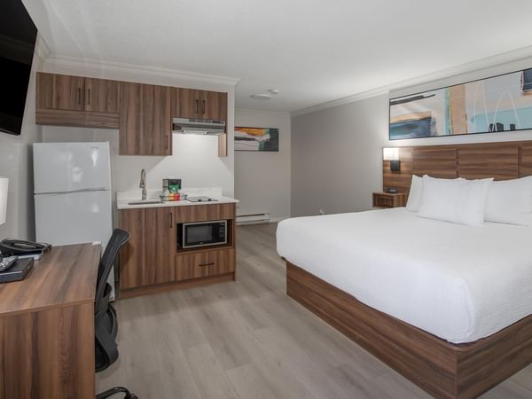 King bed, kitchenette, TV and wooden desk.