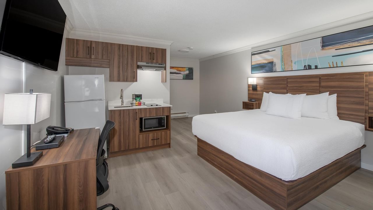 King bed, kitchenette, TV and wooden desk.
