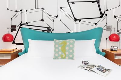 Vagabond Hotel Miami - A Mid-century modern room with white decor, teal and red accents, king bed, and bed side tables.