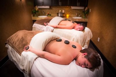 Two guests enjoy a relaxing spa treatment with hot stones at Elevation Resort and Spa.