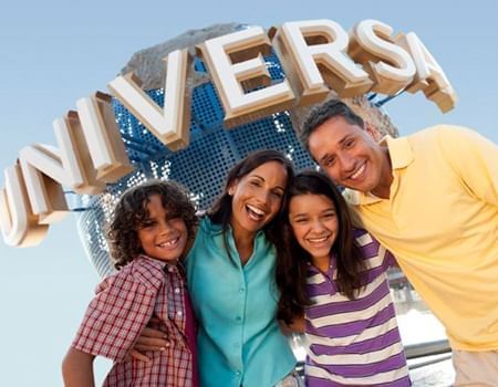 Three people posing in front of the Universal Studios globe near Lake Buena Vista Resort Village & Spa