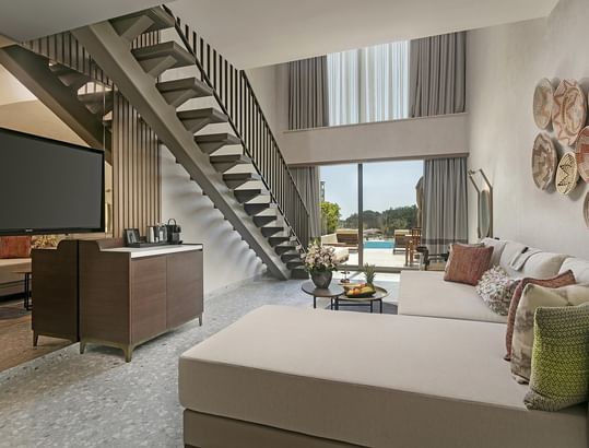 Living room with TV, staircase and view of the outdoors in Superior Duplex Swim-up at Cullinan Belek