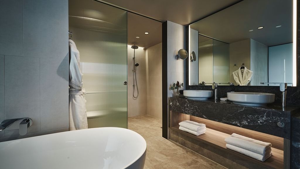 Modern Superior Suite bathroom with freestanding tub, walk-in shower, and dual vanity at Pullman East Melbourne