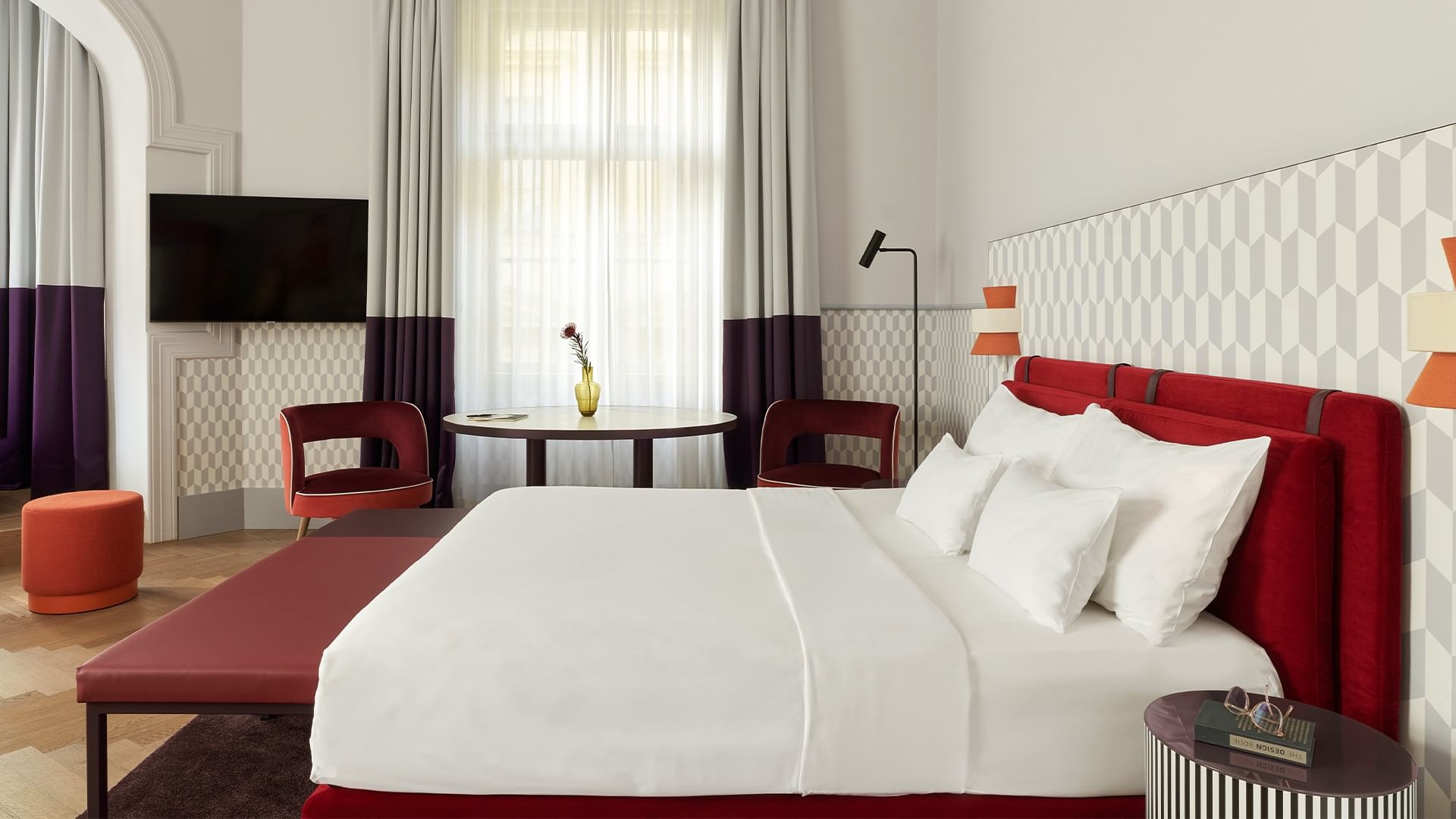 Elegantní Boutique Junior Suite s postelí, židlemi a TV v Falkensteiner Hotel Prague.