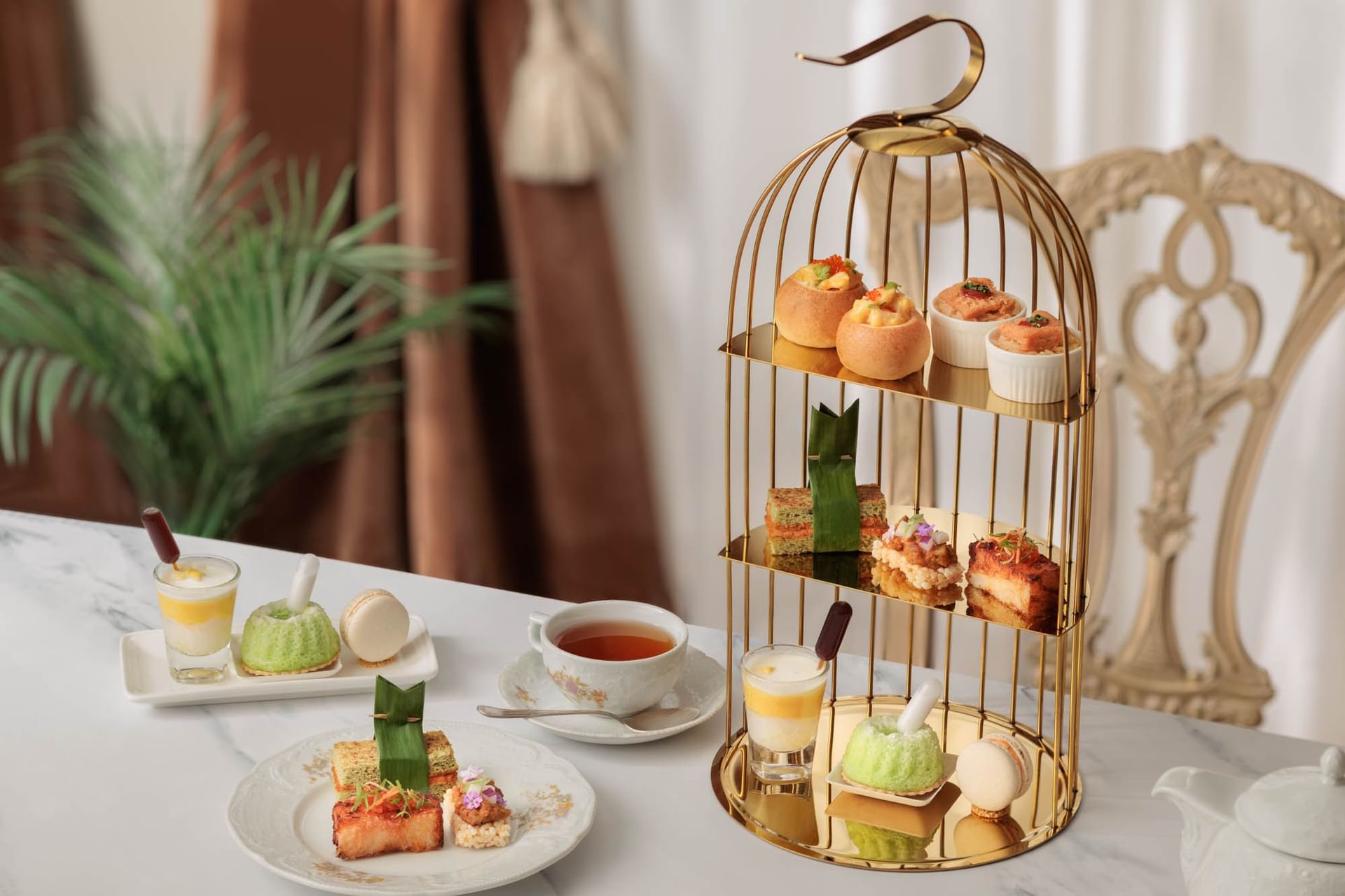 A stunning Peranakan Afternoon Tea set presented on a gold birdcage tier at Goodwood Park Hotel