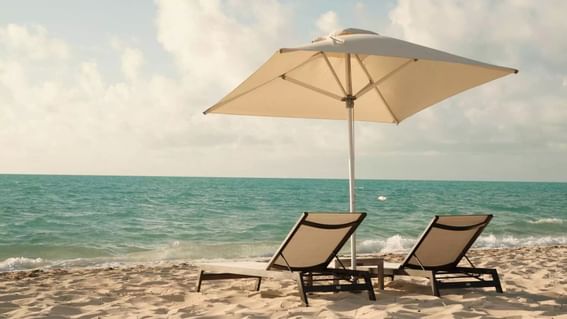 Lounge chairs & an umbrella by the beach, H2O Life Style Resort