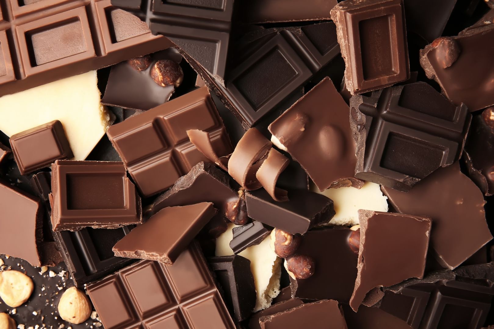 Assorted dark and white chocolate pieces piled with whole hazelnuts at Warwick Grand Place Brussels