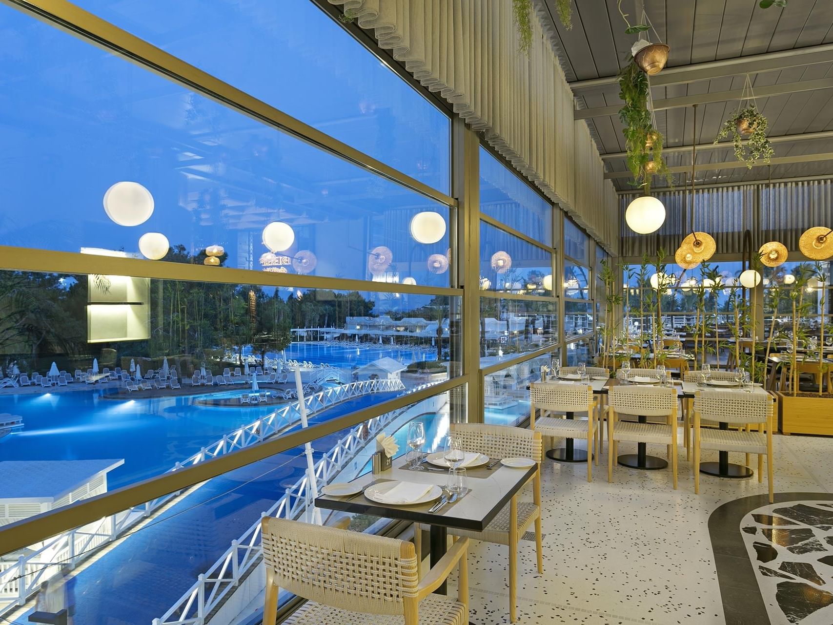 Dining tables arranged with wire knitted chairs by the window in Pascarella Italian Restaurant at Titanic Deluxe Lara