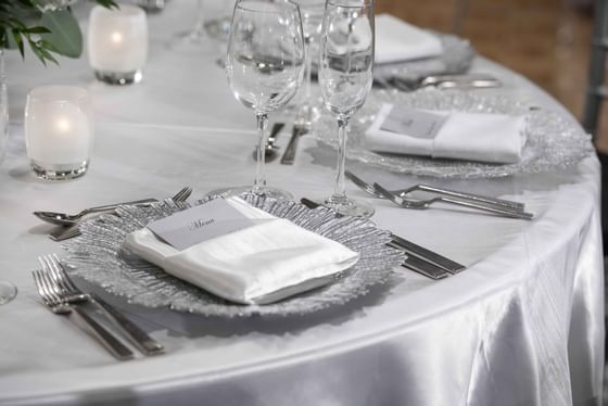 dining table with silver linen and place settings