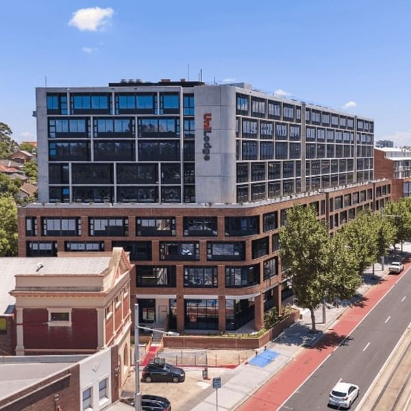 A modern purpose-built student accommodation building on a busy road