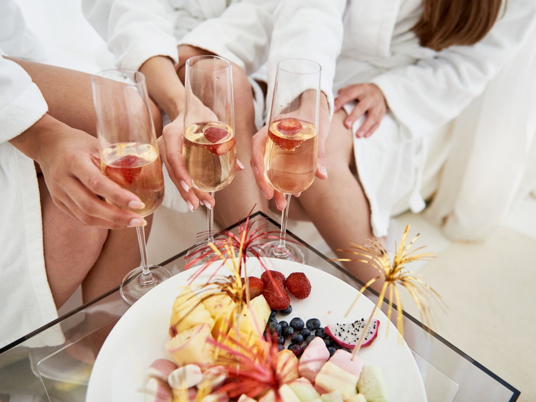 Group of people in white robes & holding champagne glasses at Ana Hotels