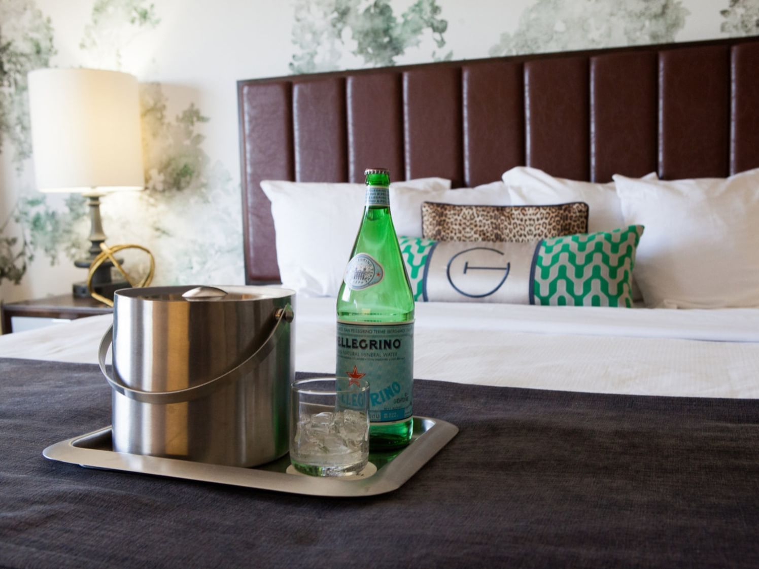 Tray with ice & sparkling water on a bed at The Grove Hotel
