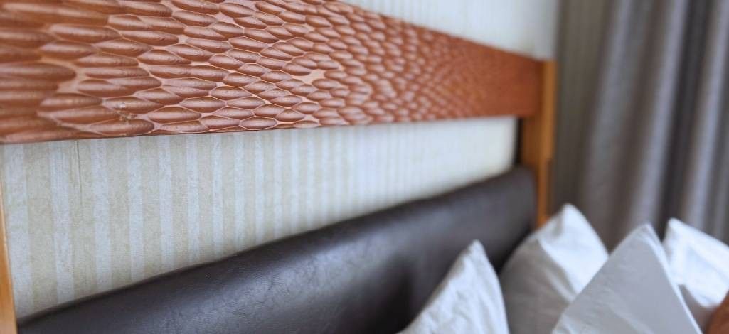 Close-up of carved wooden headboard detail in a guest room.