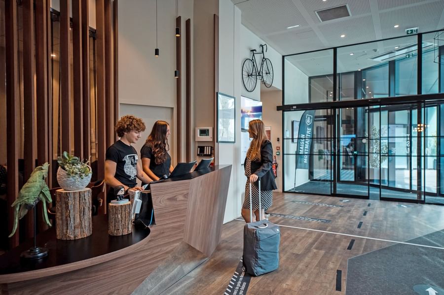 Guests checking in by the front desk at The Originals Hotels