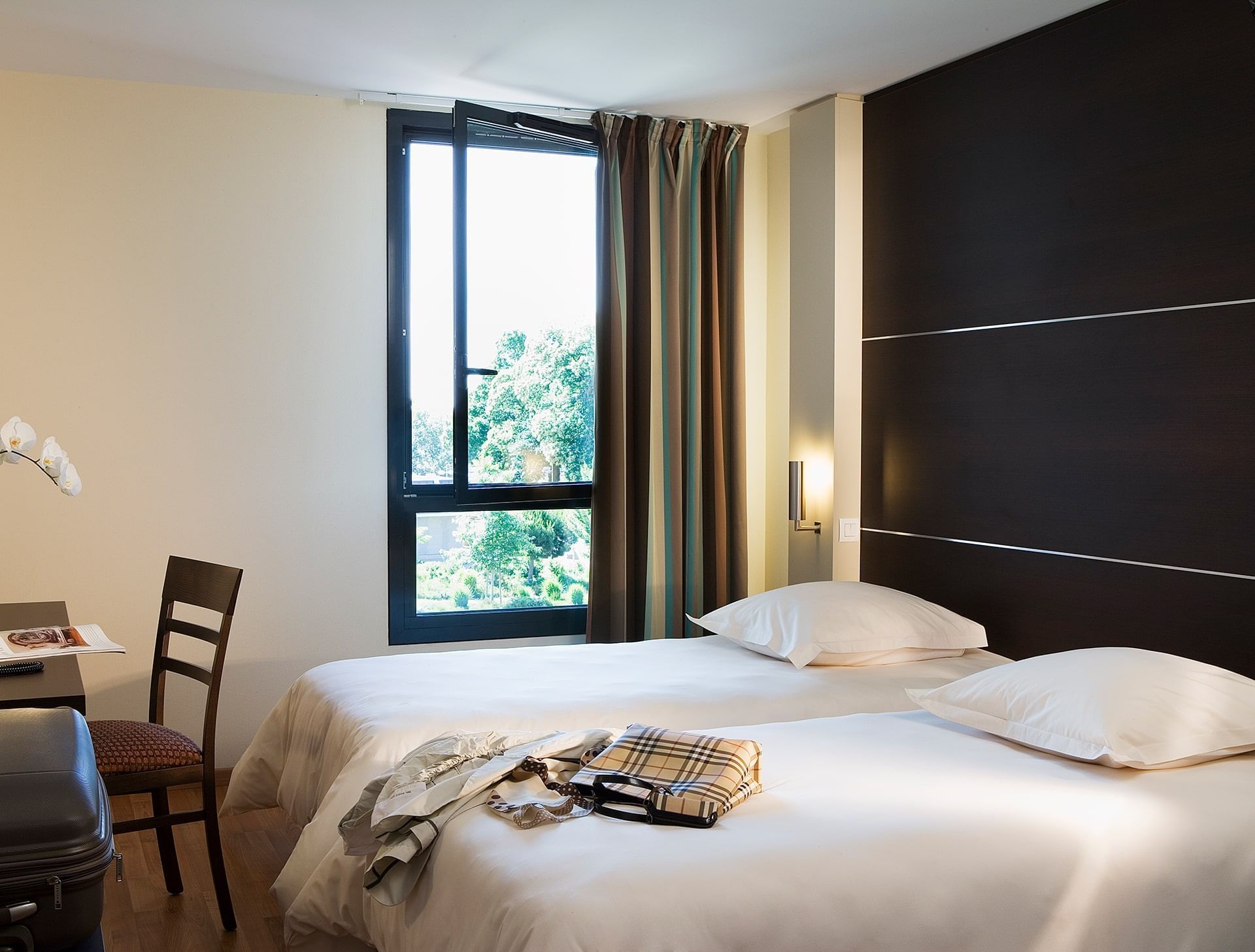 Lits jumeaux et bureau dans une chambre à l'Escale Oceania Rennes