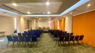 Versalles Meeting Room set up with rows of chairs facing a small stage, ready for an event at Dann Carlton Cali