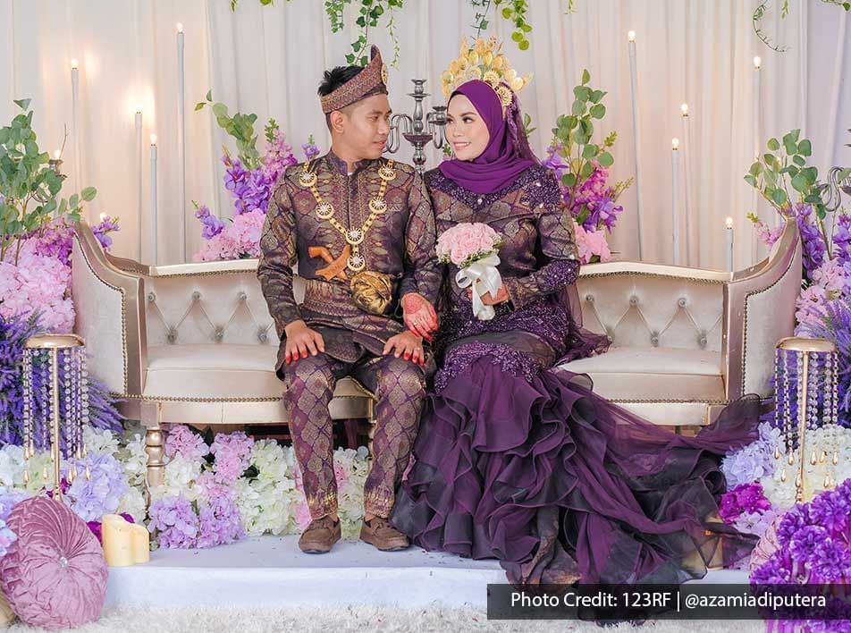 A couple was sitting next to each other in a traditional Malay wedding ceremony - Lexis Suites Penang