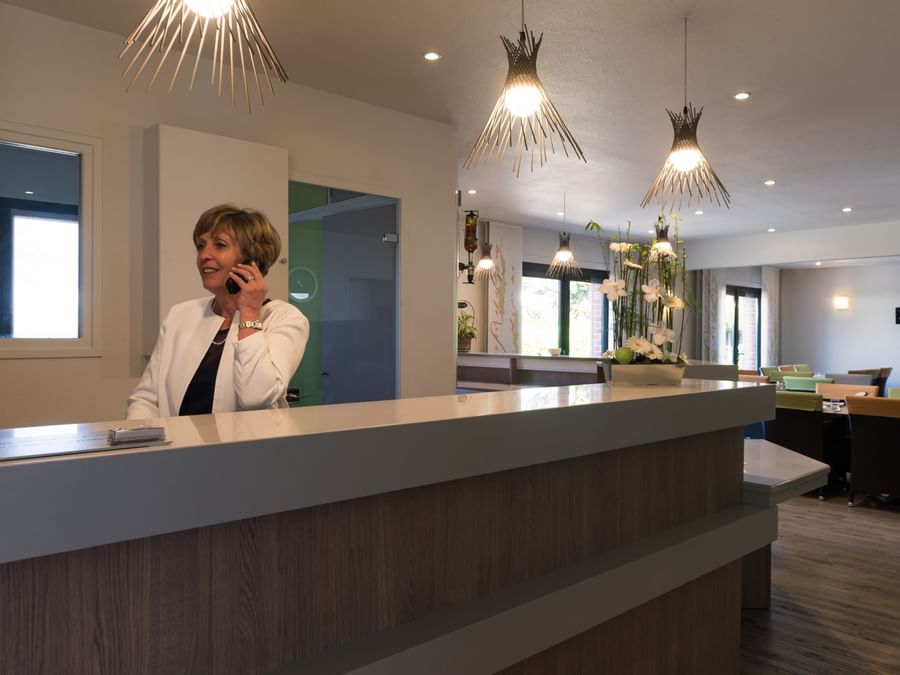 A receptionist at the reception desk in Hotel Le Gayant