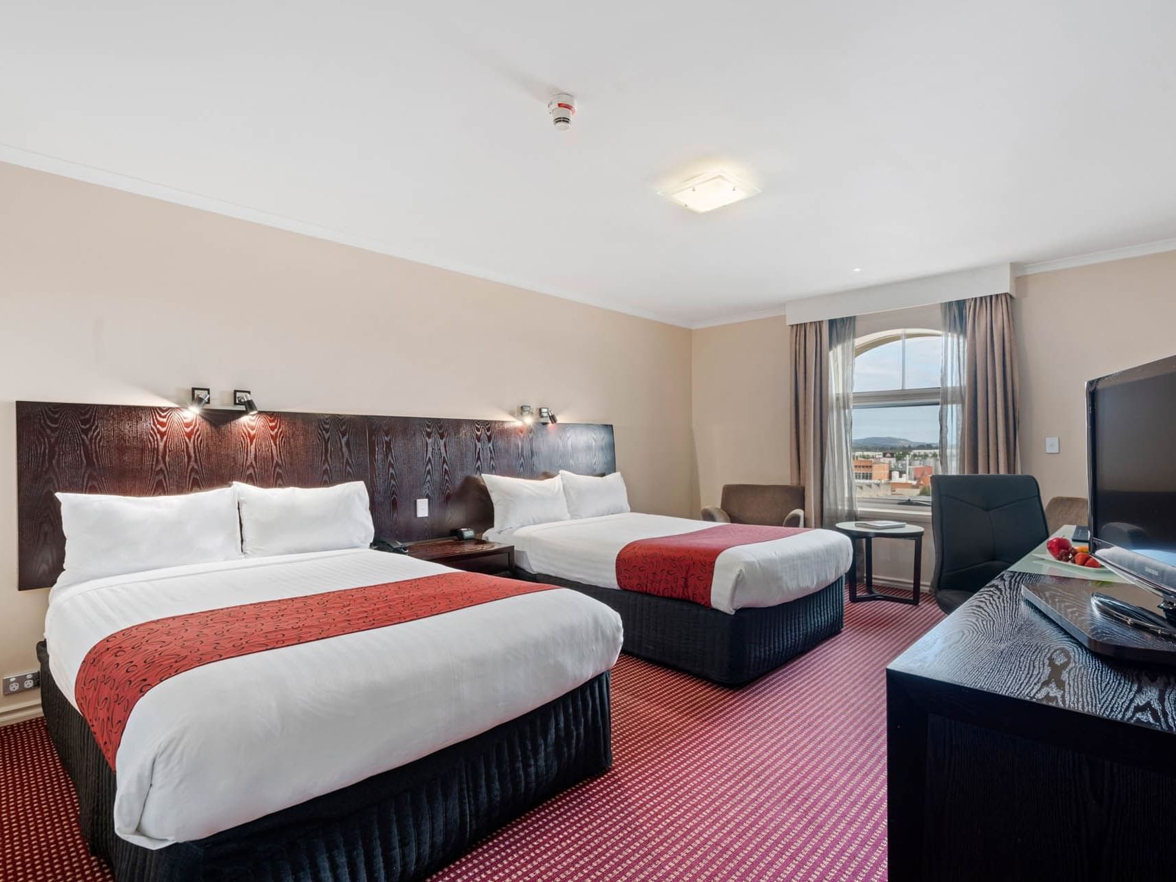 Two beds & sofas arranged by work area in Executive Twin Room at Hotel Grand Chancellor Launceston