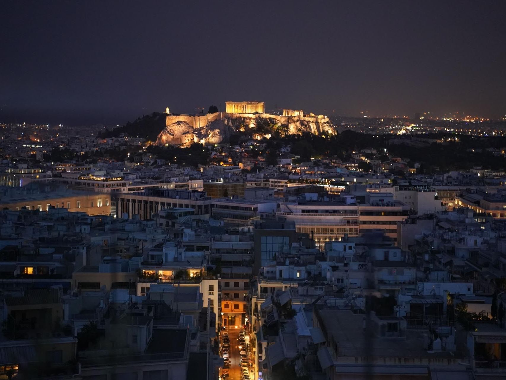 A distant view of the city at night from St George Lycabettus