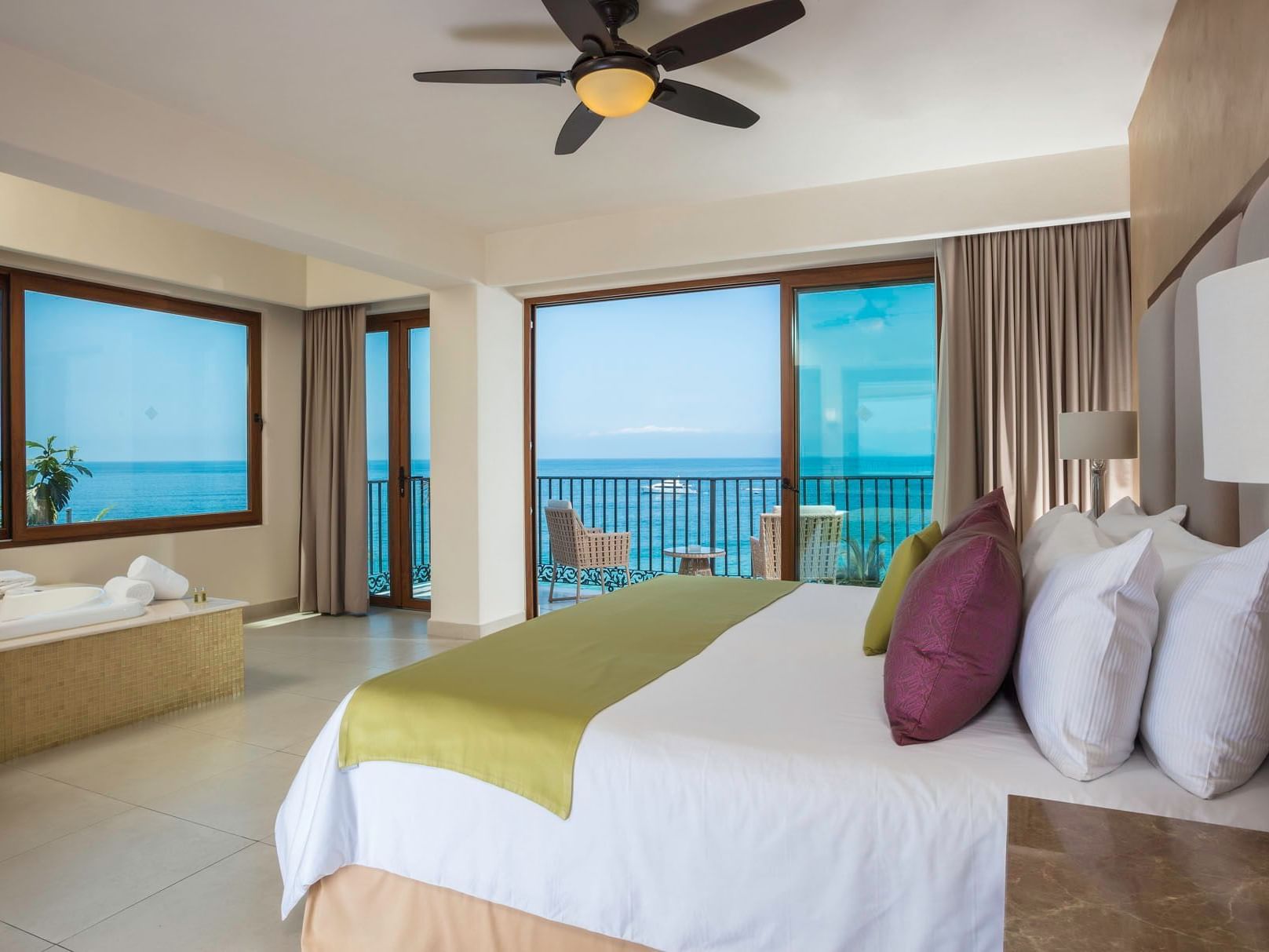 A queen bed in the Almar Deluxe Suite Partial Ocean View at Almar Beach Resort