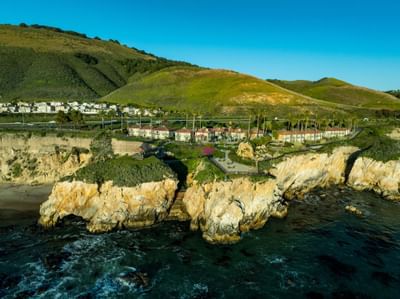 Aerial view of hotel and Pismo Preserve with green hills