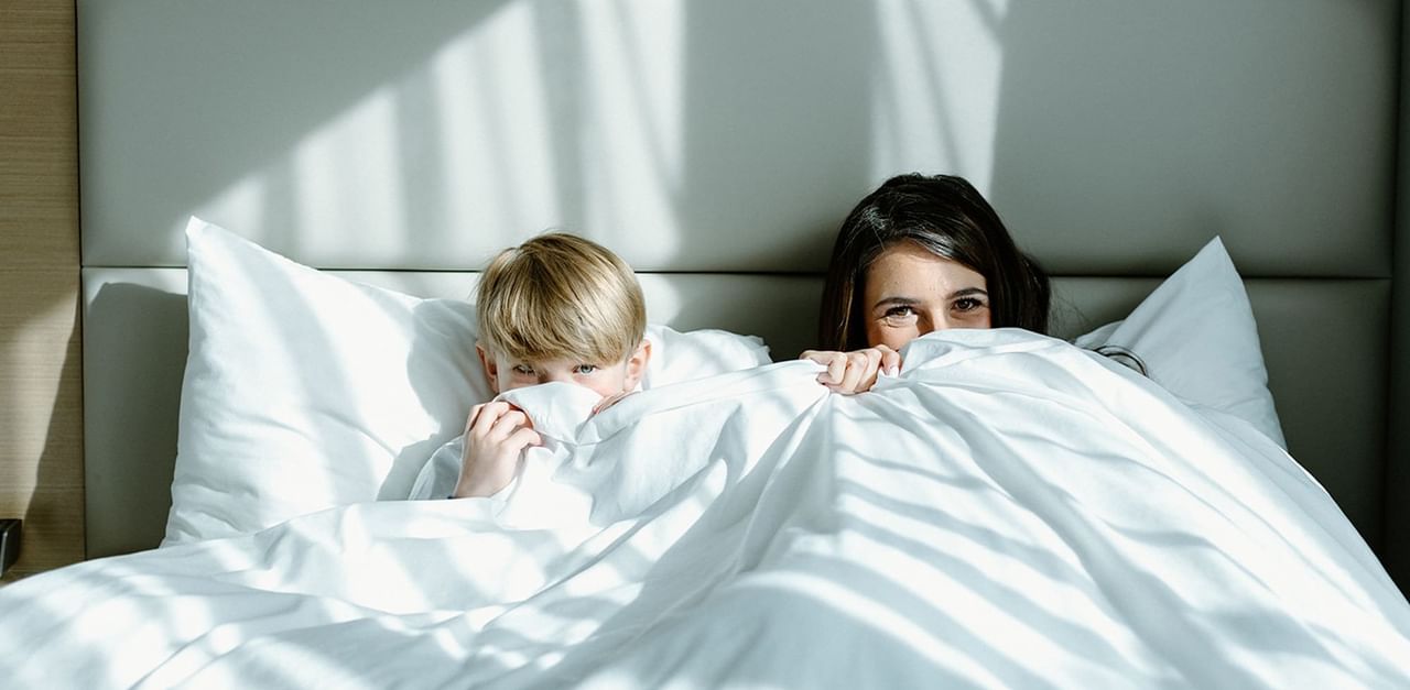 Mother and Child hiding under the covers at Coast Tsawwassen Inn