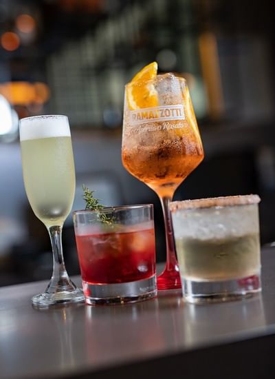 Selection of handcrafted cocktails served in glasses standing on a bar counter at Veranda Restaurant in Veranda Hotel