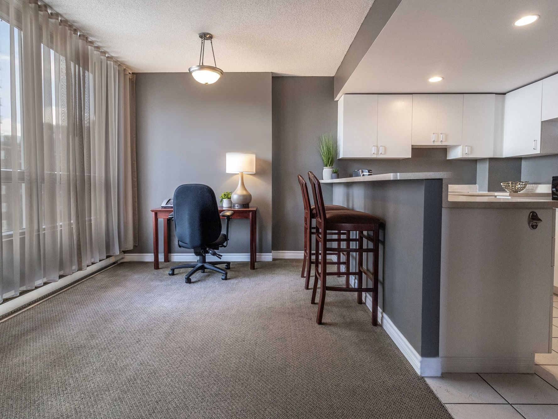 king_studio_desk_and_kitchenette_area_at_hotel_faubourg_montreal