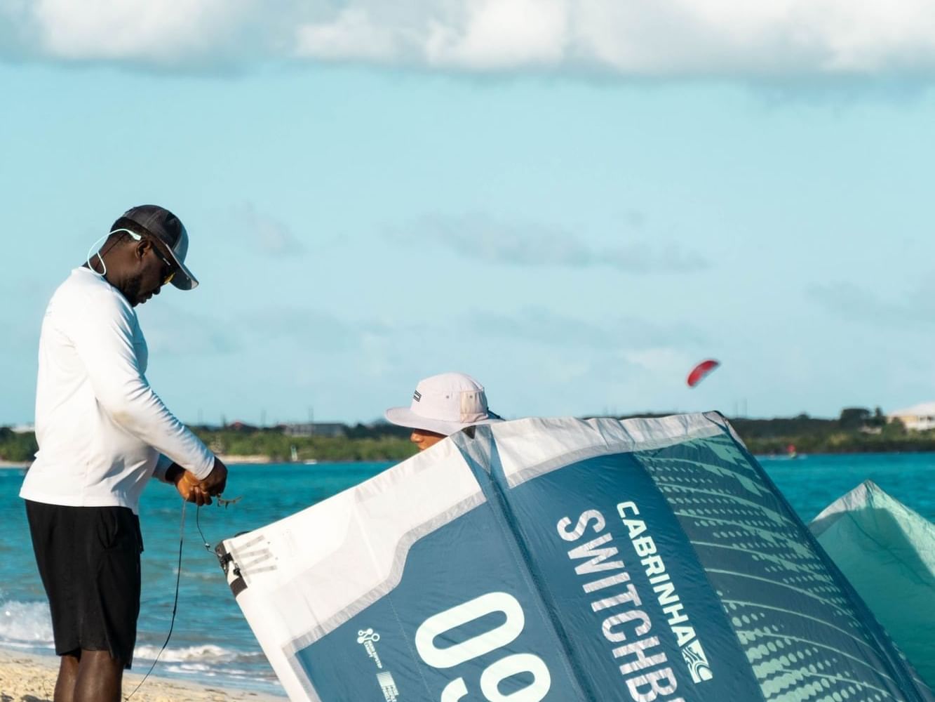 Instructor setting a kite by the beach, H2O Life Style Resort